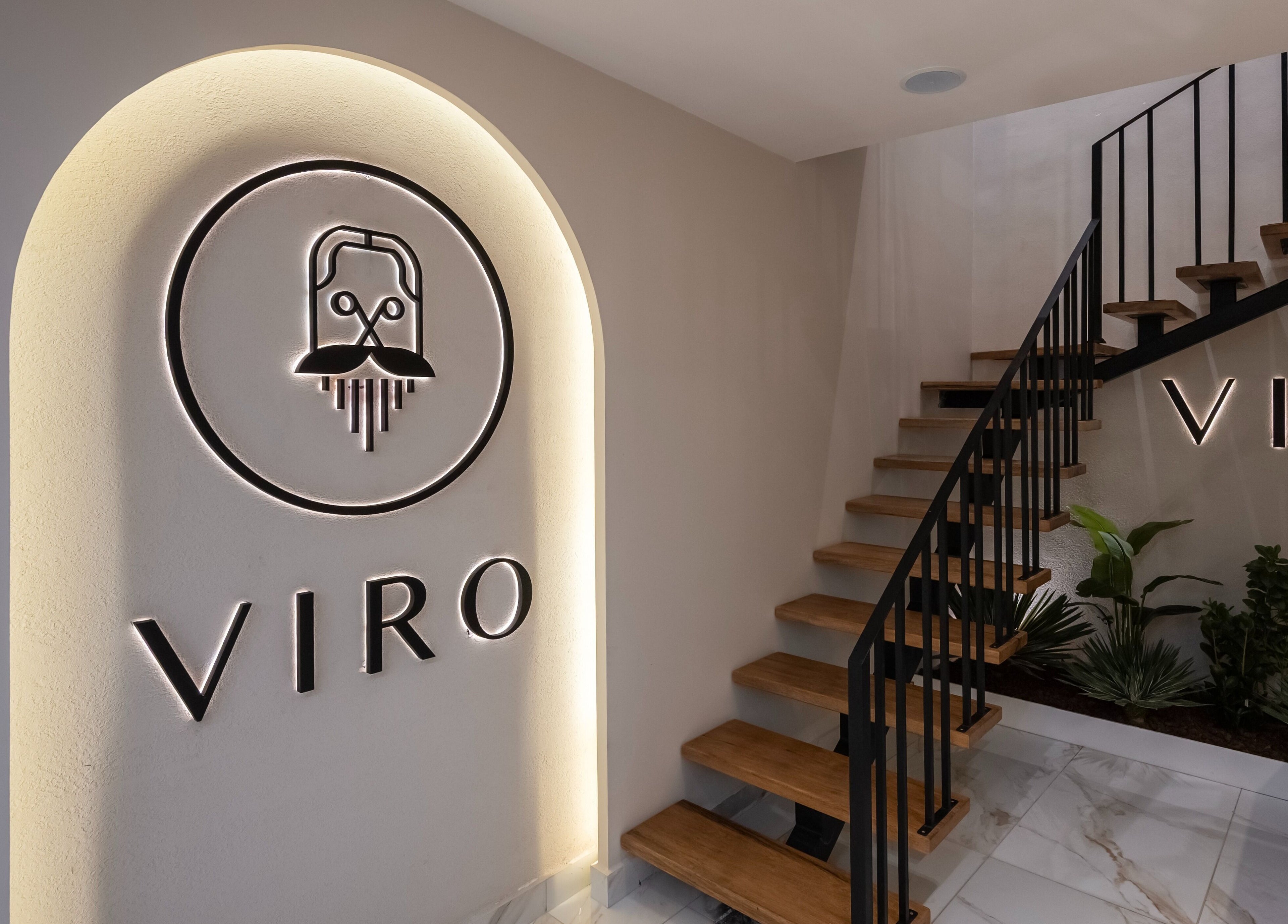 Sophisticated entrance at VIRO Barbershop Dabouq, Amman, featuring modern design and wooden stairs.