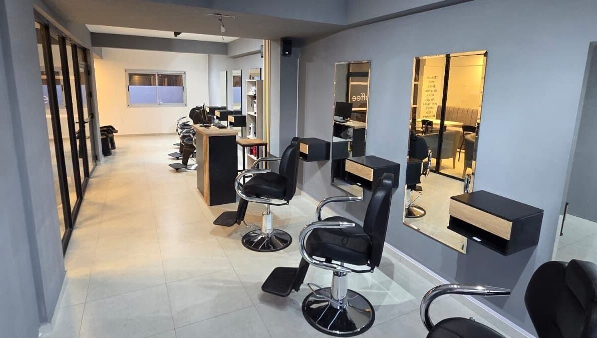 Interior elegante de Glam & Coffee en Wilde, Provincia De Buenos Aires, AR. Sillas de peluquería y espejos amplios.