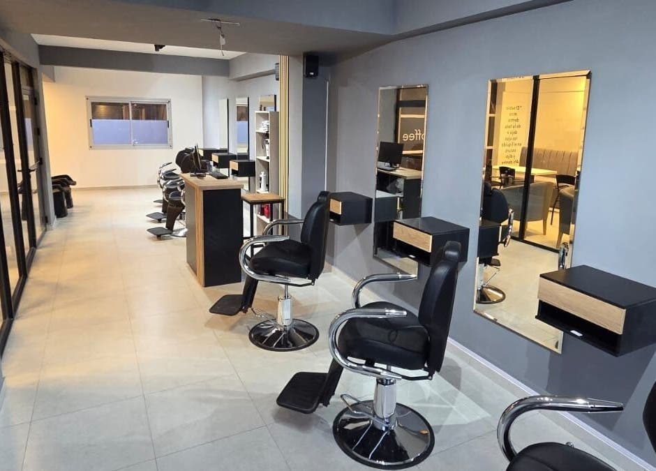 Interior elegante de Glam & Coffee en Wilde, Provincia De Buenos Aires, AR. Sillas de peluquería y espejos amplios.