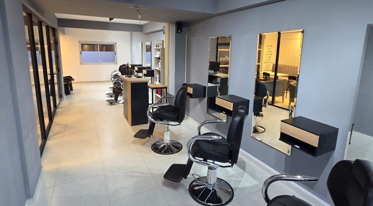 Interior elegante de Glam & Coffee en Wilde, Provincia De Buenos Aires, AR. Sillas de peluquería y espejos amplios.