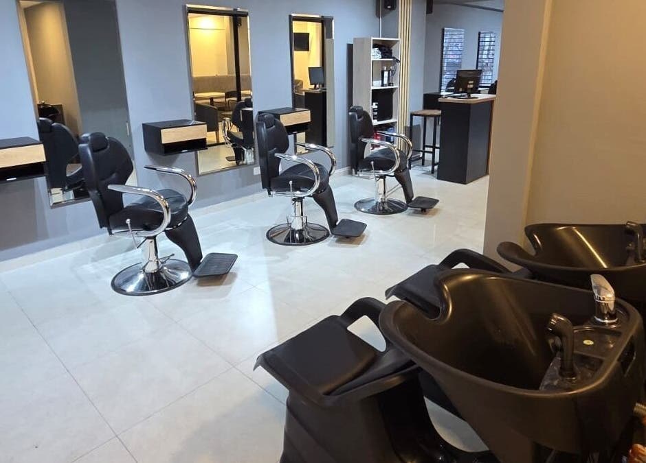 Interior moderno de Glam & Coffee en Wilde, Provincia De Buenos Aires, AR, mostrando sillas de peluquería y lavacabezas.