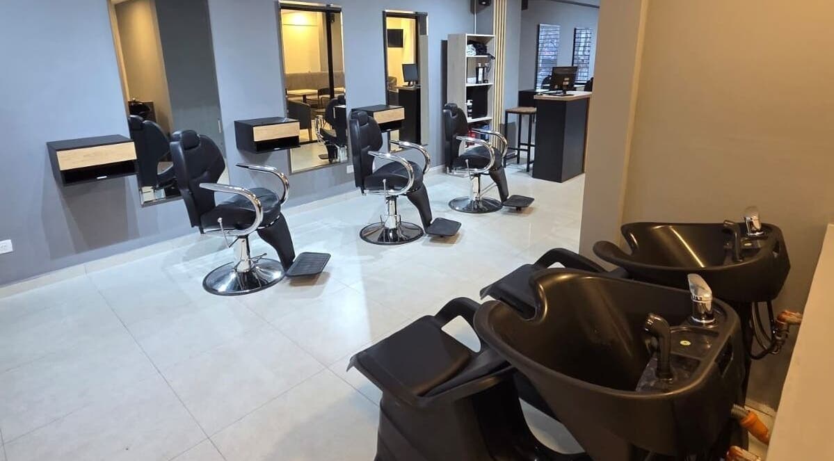 Interior moderno de Glam & Coffee en Wilde, Provincia De Buenos Aires, AR, mostrando sillas de peluquería y lavacabezas.