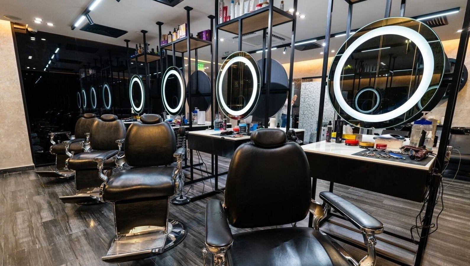 Stylish interior of Sams Barber Men Care Center in Abu Dhabi featuring modern chairs and illuminated mirrors.