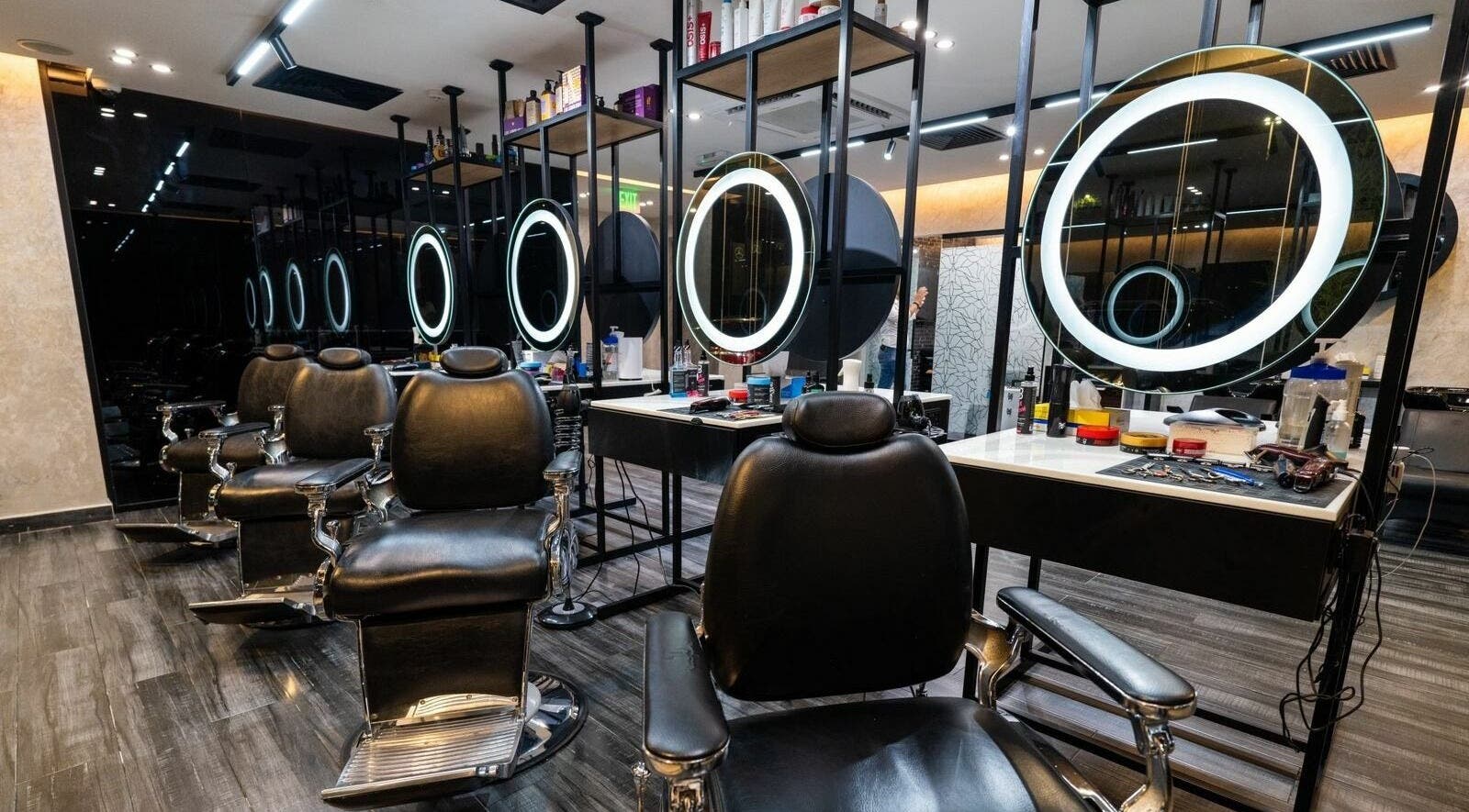 Stylish interior of Sams Barber Men Care Center in Abu Dhabi featuring modern chairs and illuminated mirrors.