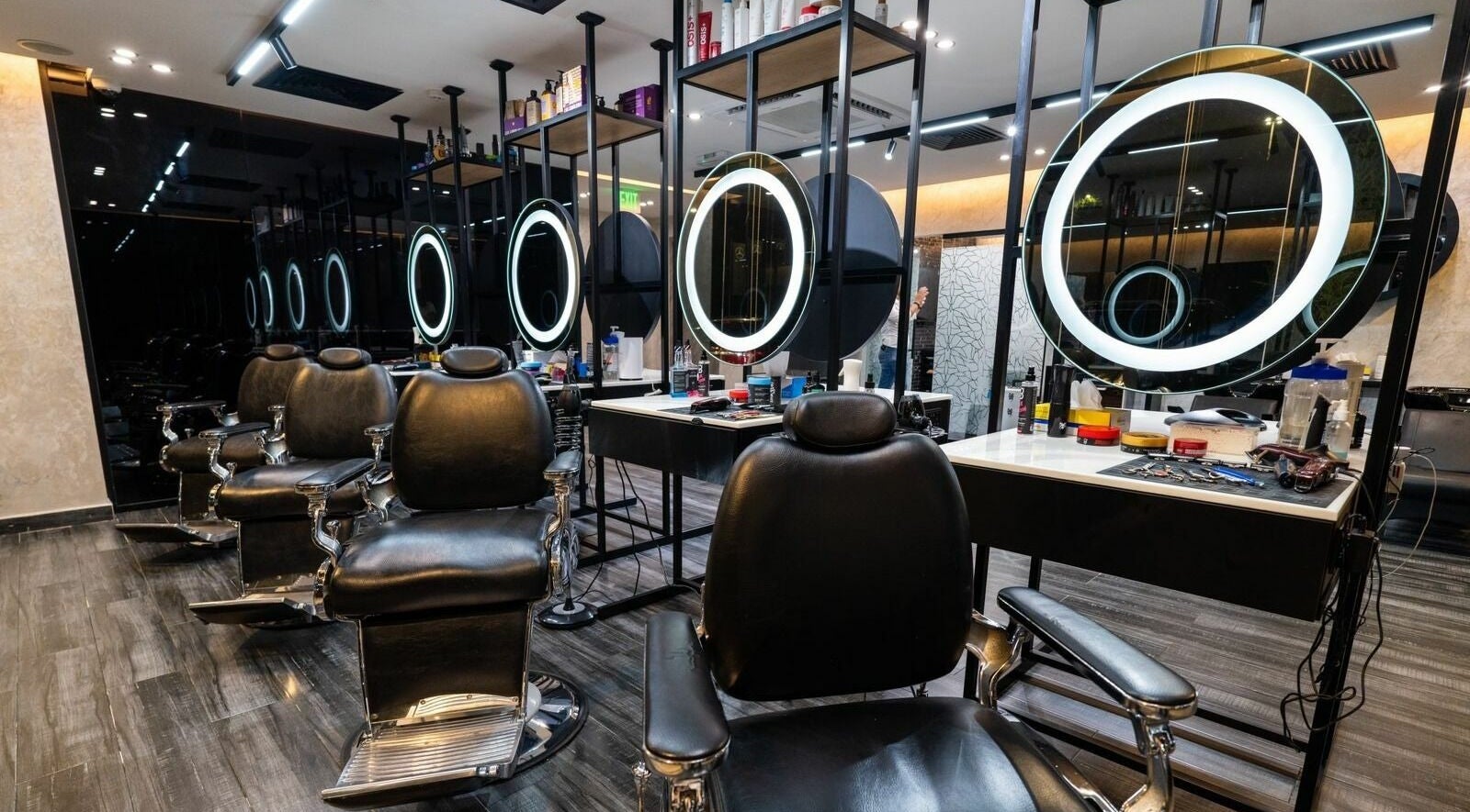 Stylish interior of Sams Barber Men Care Center in Abu Dhabi featuring modern chairs and illuminated mirrors.