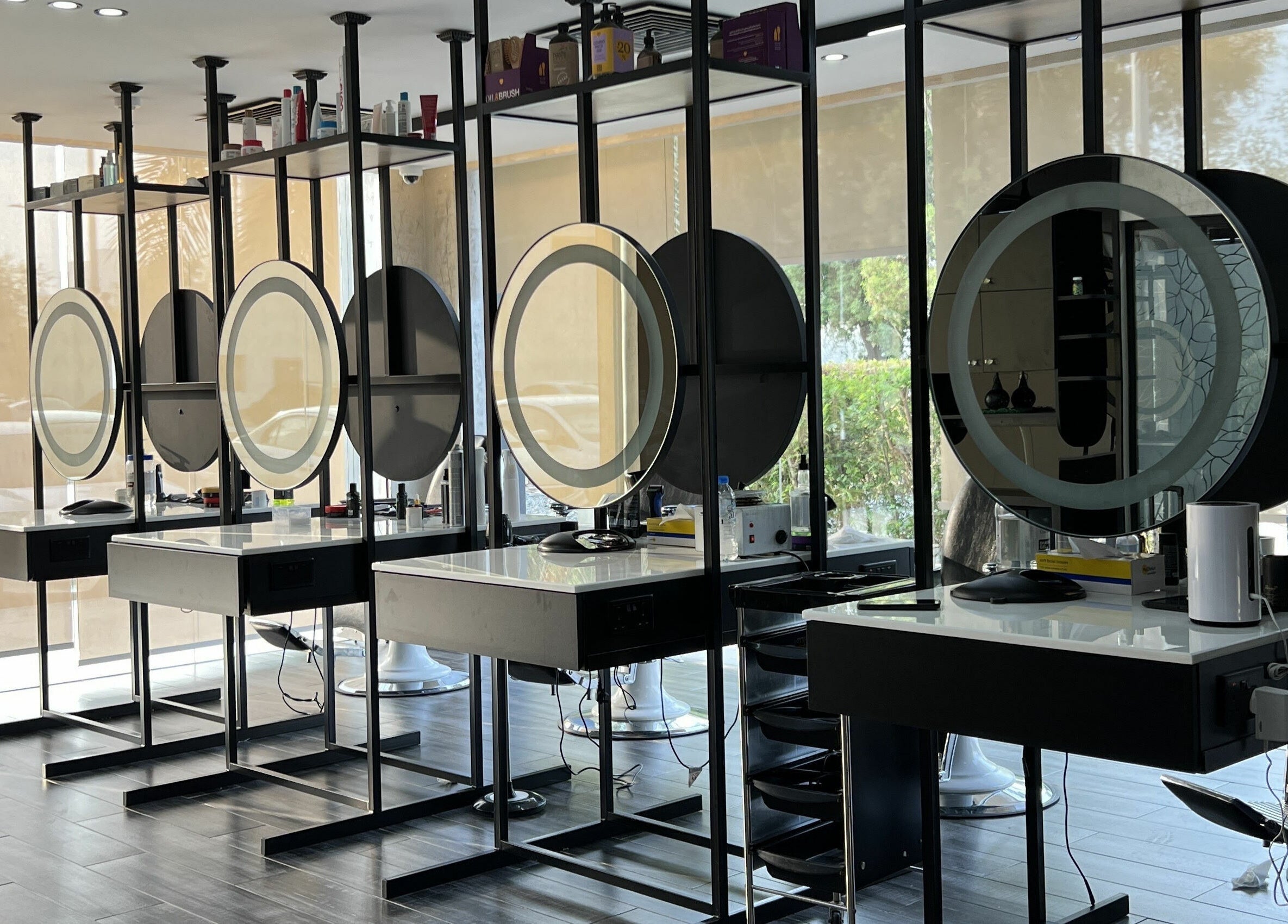 Chic styling stations at Sams Barber Men Care Center, Abu Dhabi, AE, with round mirrors and sleek decor.