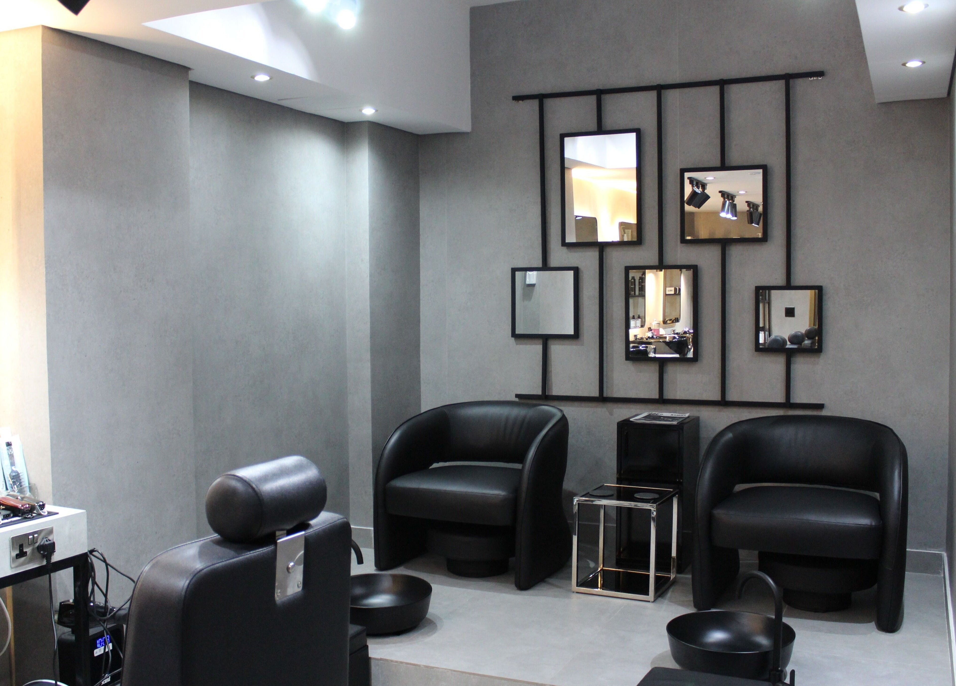 Modern salon interior at The Salon Luxe in Dubai, Dubai, AE featuring sleek black chairs and stylish mirrors.