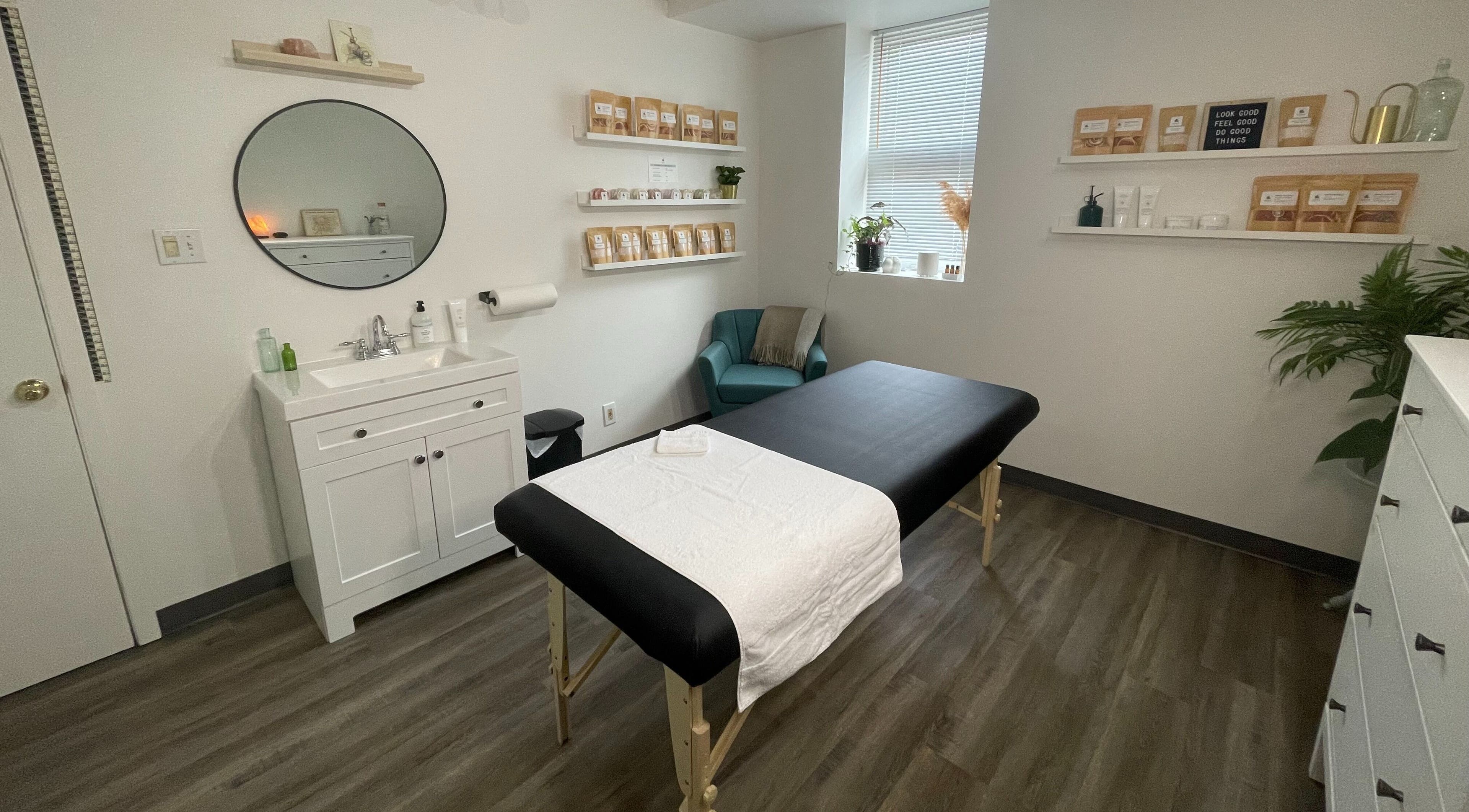 Tranquil therapy room at Natural Embrace Skin Spa (NESS) in Pelham, Ontario, CA with massage bed and decor.