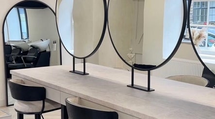 Elegant salon interior at Glam by Laura featuring round mirrors and styling chairs in Sheffield, England, GB.