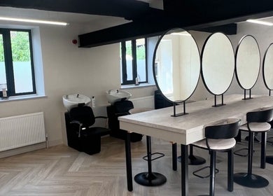 Chic salon interior at Glam by Laura in Sheffield, England, GB with mirrors, chairs, and wash basins.