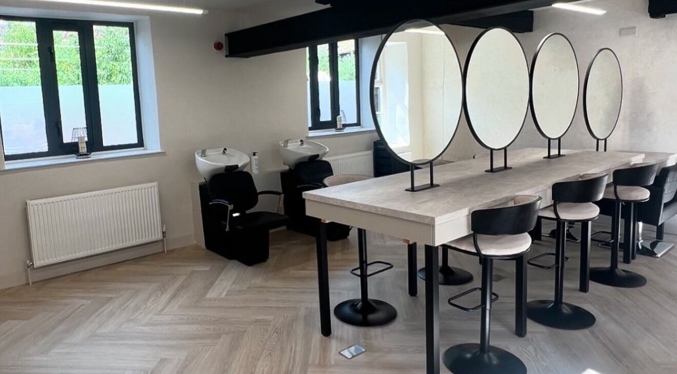 Chic beauty station at Glam by Laura in Sheffield, England, GB featuring modern black chairs and round mirrors.