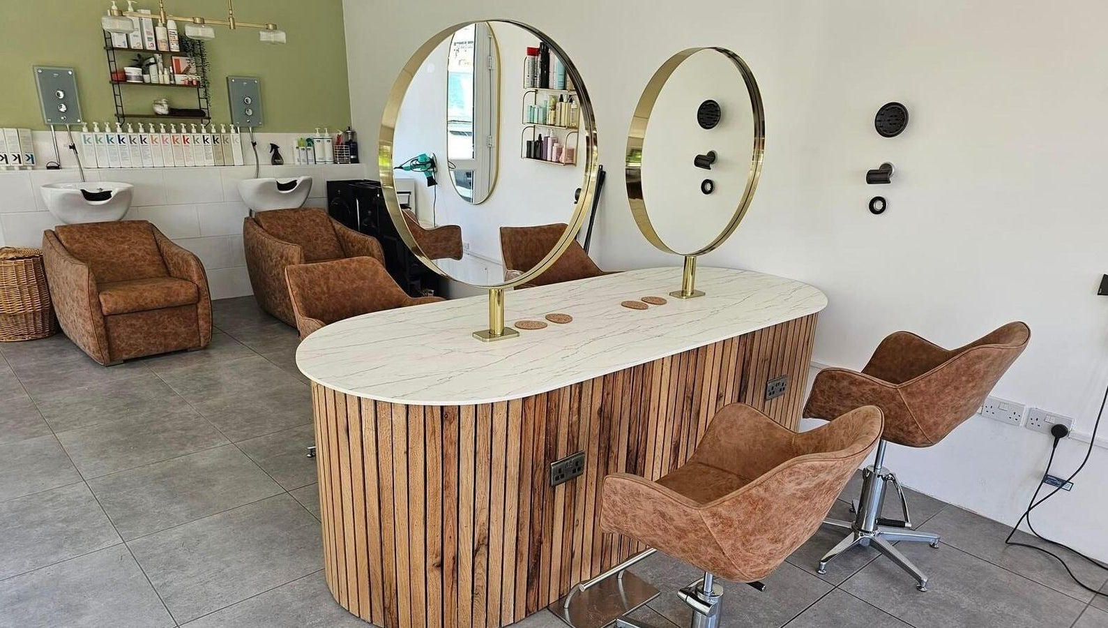 Modern salon interior at Hair Twenty-Two in Bridport, England, GB with stylish chairs and mirrors.