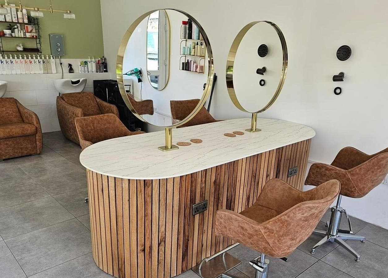 Modern salon interior at Hair Twenty-Two in Bridport, England, GB with stylish chairs and mirrors.