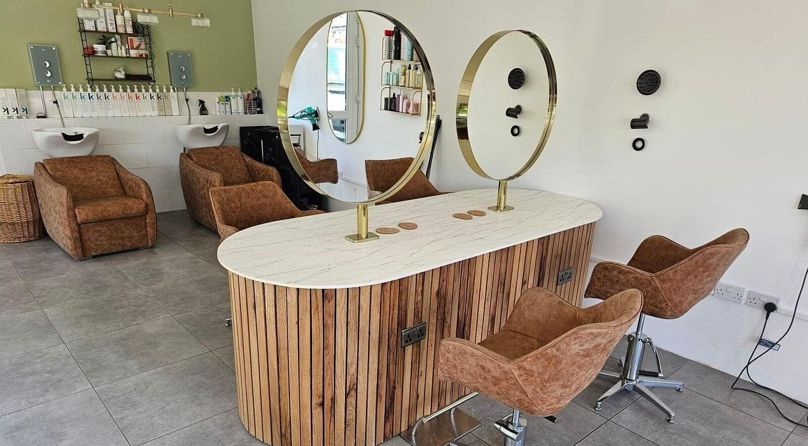 Modern salon interior at Hair Twenty-Two in Bridport, England, GB with stylish chairs and mirrors.
