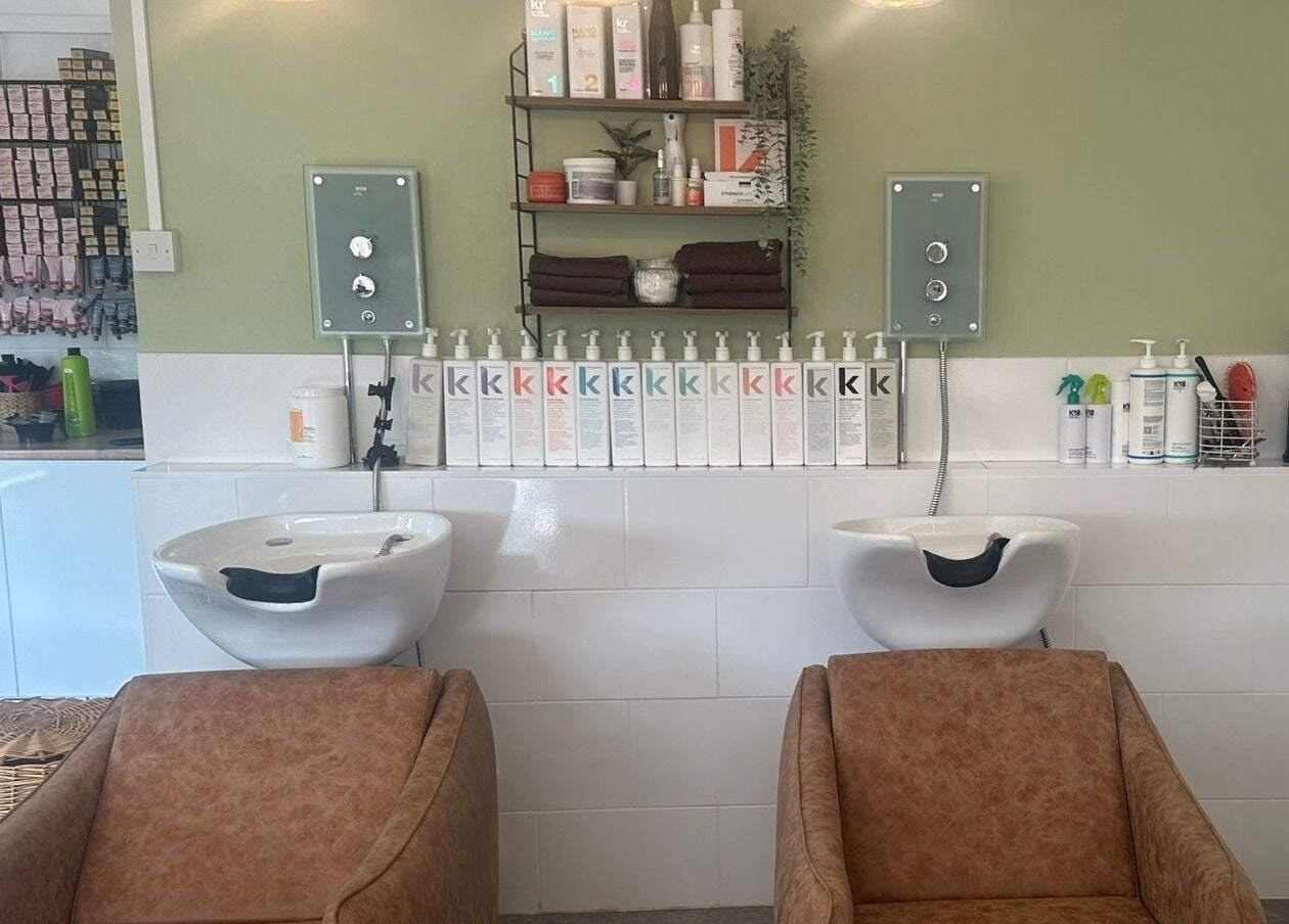 Stylish hair wash area at Hair Twenty-Two, Bridport, England, GB with products neatly displayed.