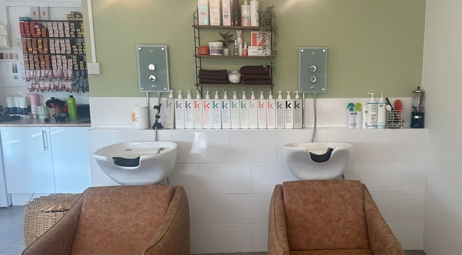 Stylish hair wash area at Hair Twenty-Two, Bridport, England, GB with products neatly displayed.