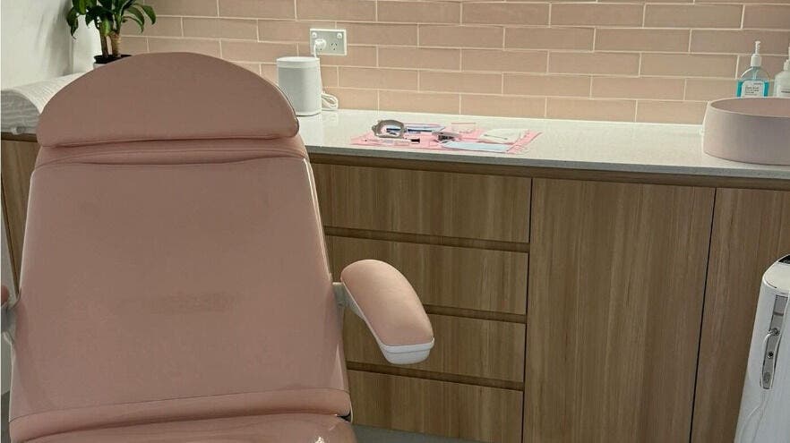 Cozy treatment room at The Teeth Whitening Boutique - Brisbane, Teneriffe, Queensland, AU with a soft pink chair and supplies.