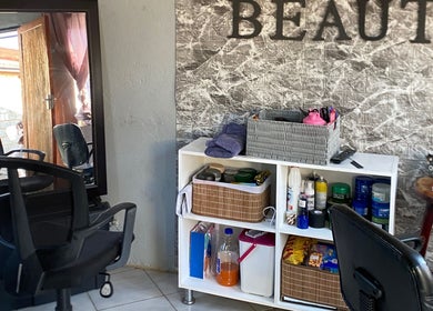Interior of TT Beauty in Meadowlands West, Gauteng, ZA featuring chairs, styling products, and a mirror.