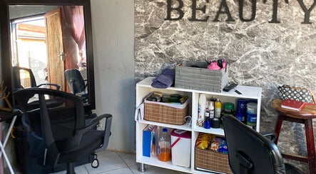 Interior of TT Beauty in Meadowlands West, Gauteng, ZA featuring chairs, styling products, and a mirror.