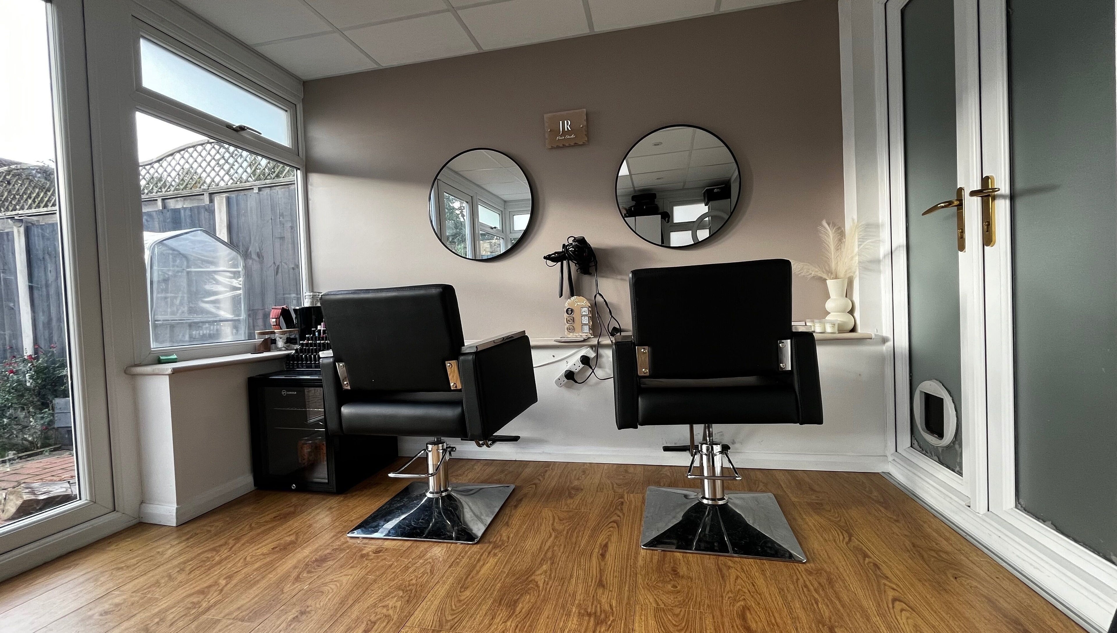 Stylish chairs and mirrors at JR Hair Studio, Walnut Tree, England, GB, offering a modern ambiance.
