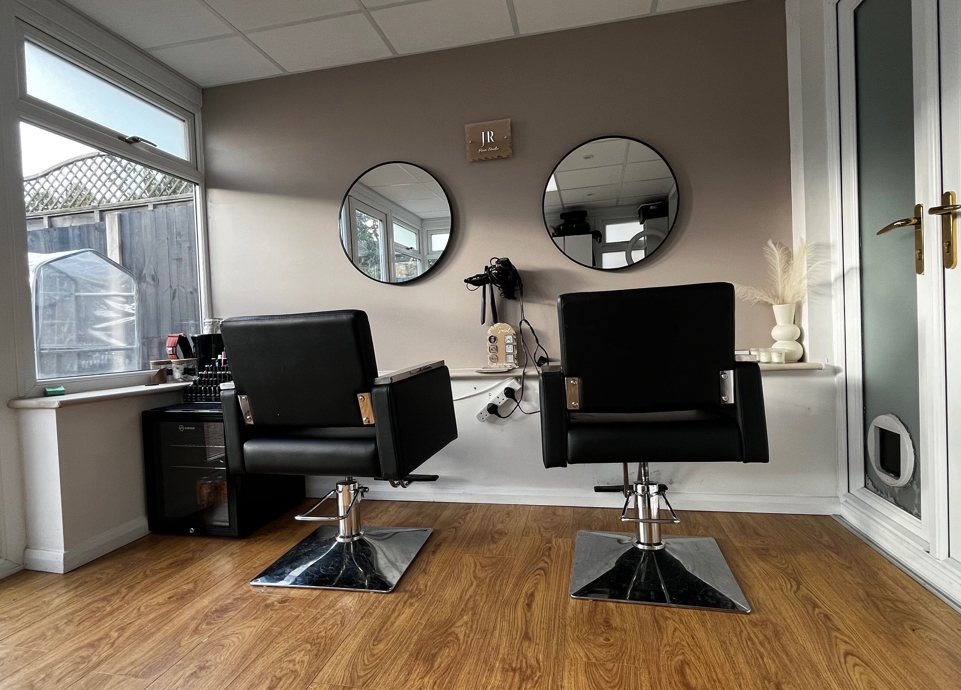 Stylish chairs and mirrors at JR Hair Studio, Walnut Tree, England, GB, offering a modern ambiance.
