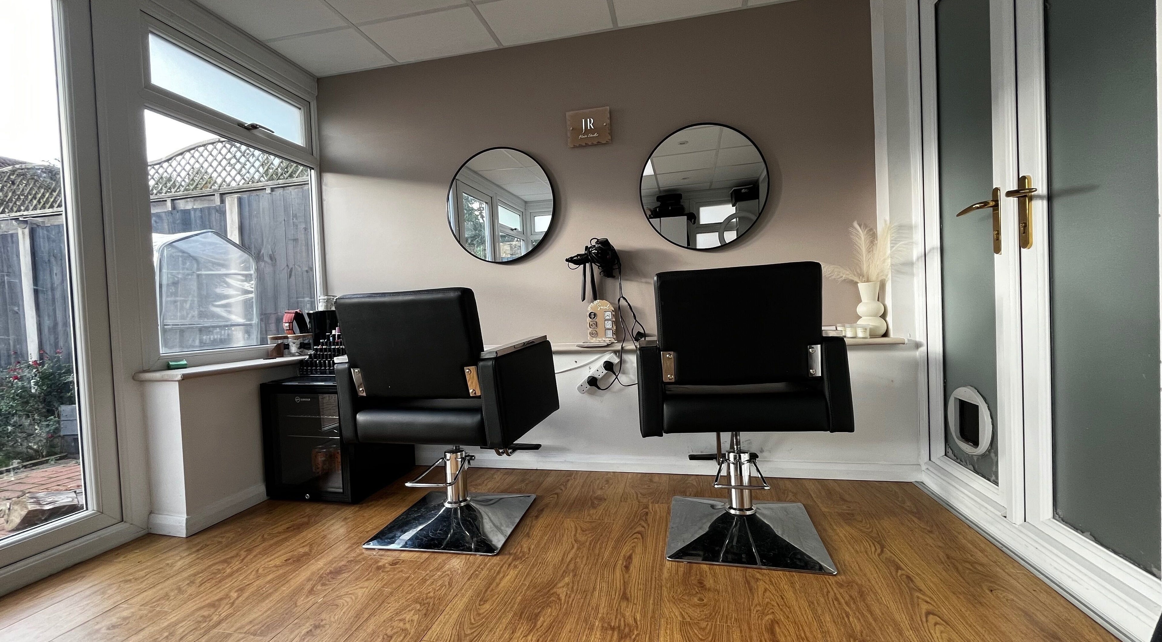 Stylish chairs and mirrors at JR Hair Studio, Walnut Tree, England, GB, offering a modern ambiance.