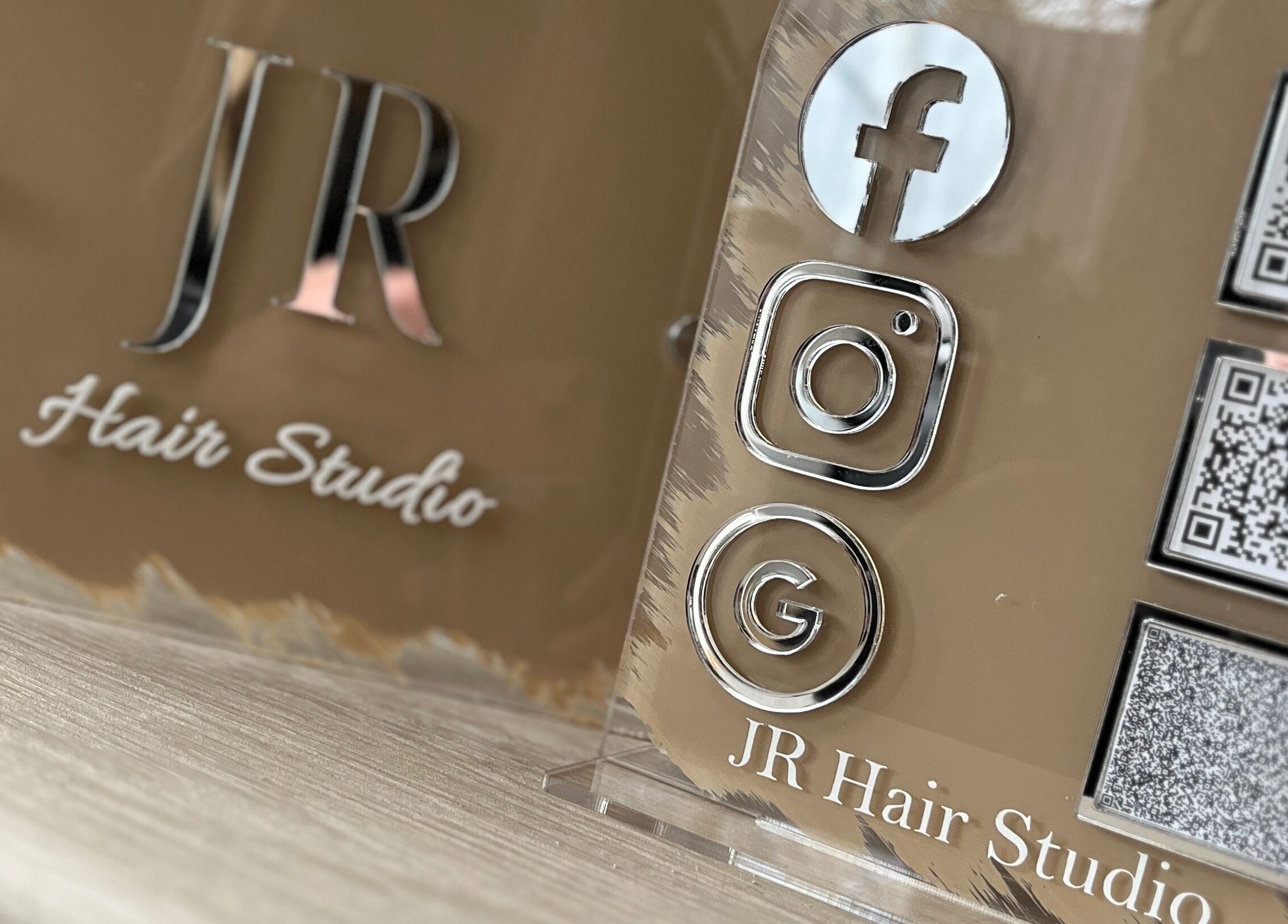 JR Hair Studio's social media display at Walnut Tree, England, GB with QR codes and logos.