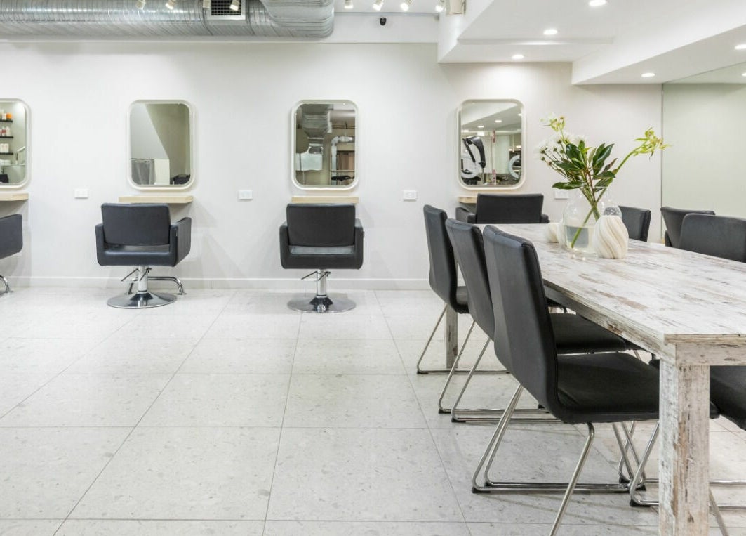 Chic hair salon interior at House of Lox Neutral Bay, New South Wales, AU, featuring sleek chairs and mirrors.