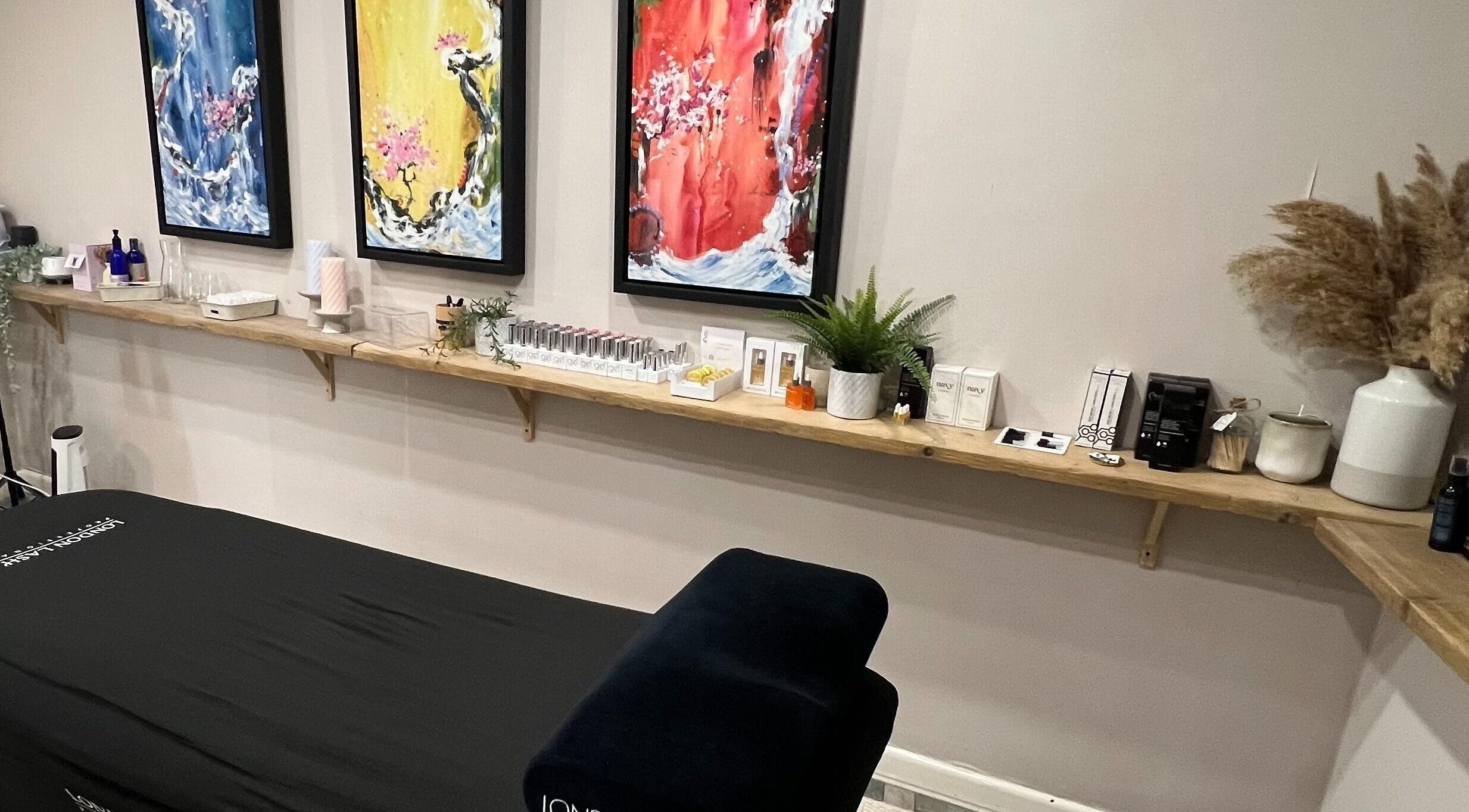 Wellness treatment room at The Occhi Lounge, Yeovil, England, GB featuring elegant decor and vibrant artwork.