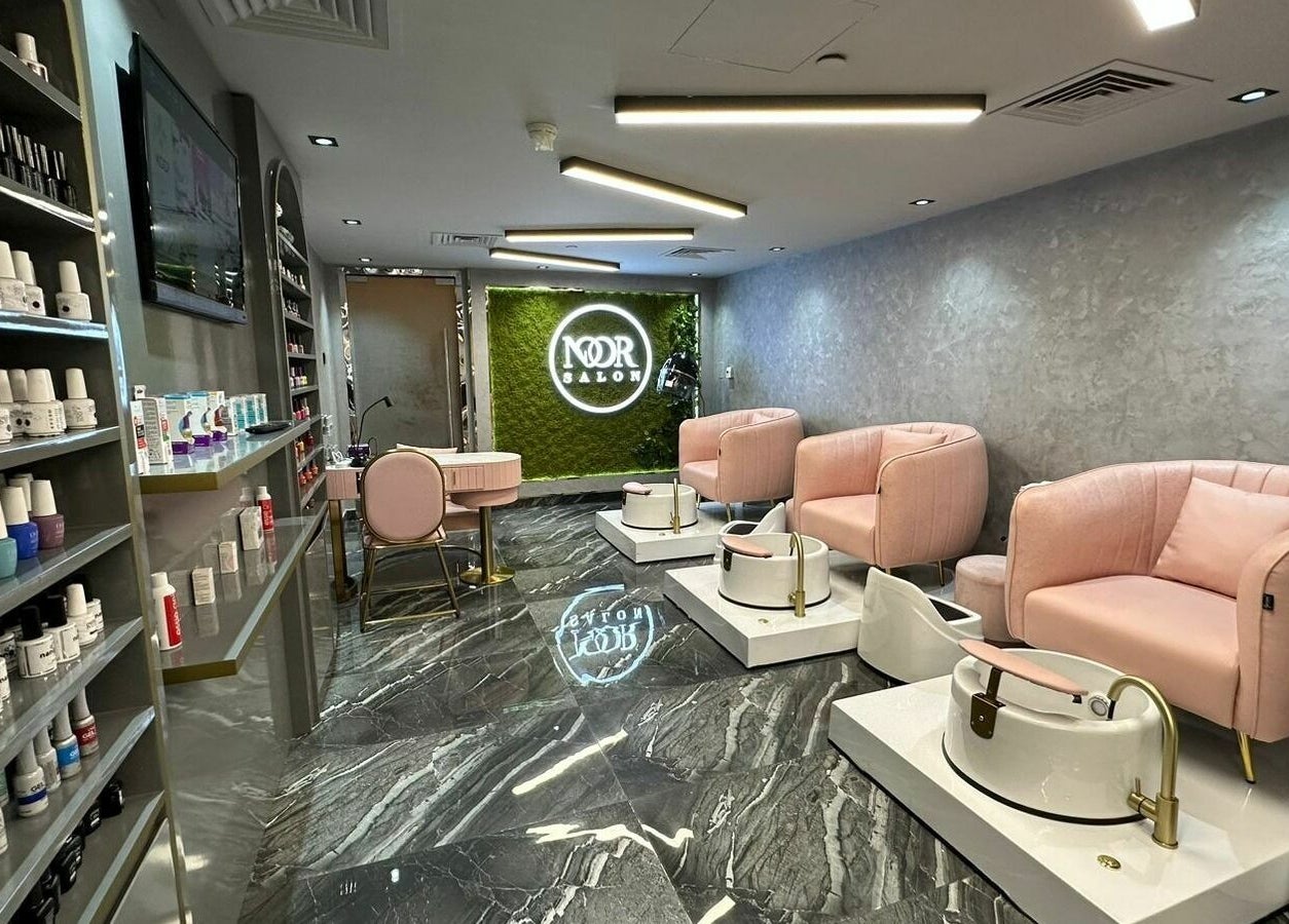 Luxurious pedicure area at Noor Beauty Salon | Beach Rotana, Abu Dhabi, AE with plush pink chairs and chic decor.