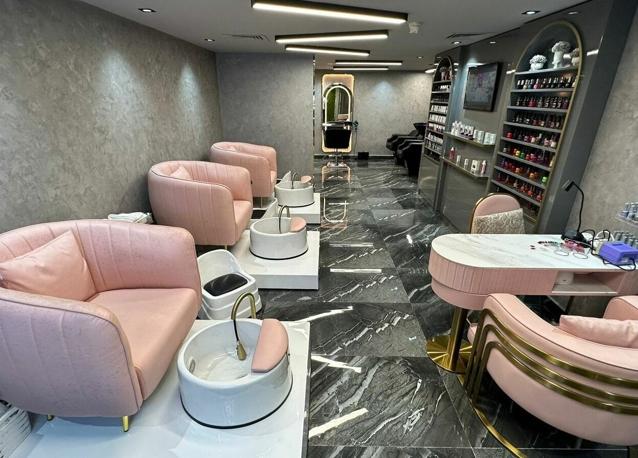 Elegant interior of Noor Beauty Salon | Beach Rotana, Abu Dhabi, AE with plush seating and sleek nail stations.