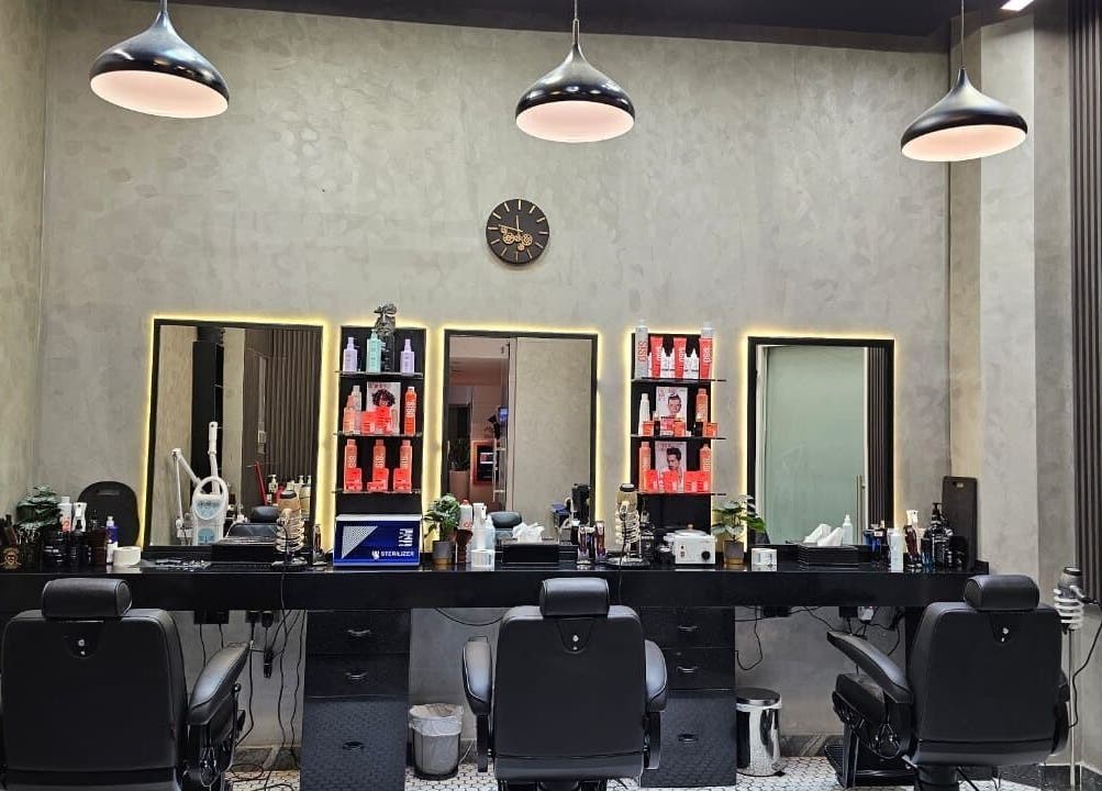 Chic modern interior of Noor Elasr Gents | Le Meridien in Abu Dhabi, AE, featuring plush barber chairs and elegant decor.