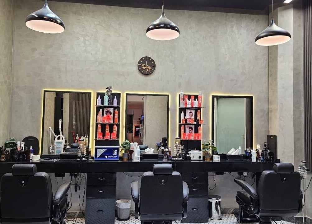 Chic modern interior of Noor Elasr Gents | Le Meridien in Abu Dhabi, AE, featuring plush barber chairs and elegant decor.