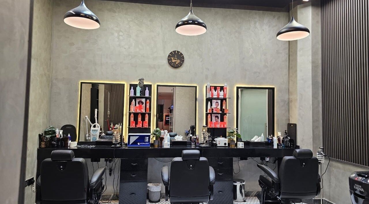 Chic modern interior of Noor Elasr Gents | Le Meridien in Abu Dhabi, AE, featuring plush barber chairs and elegant decor.