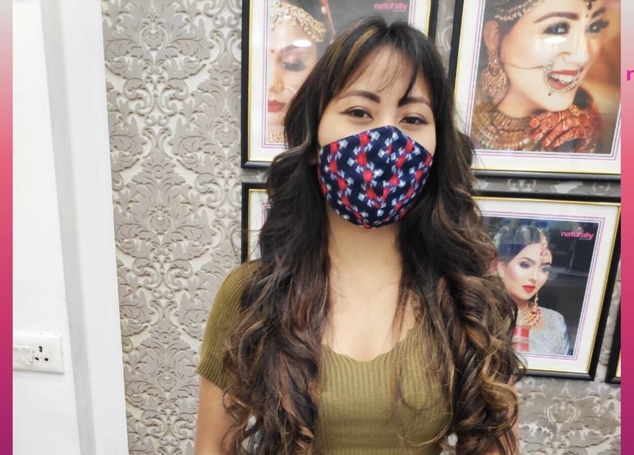 Client at Naturally Yours Salon in Navi Mumbai, Maharashtra, IN, wearing a mask and styled with curled hair.