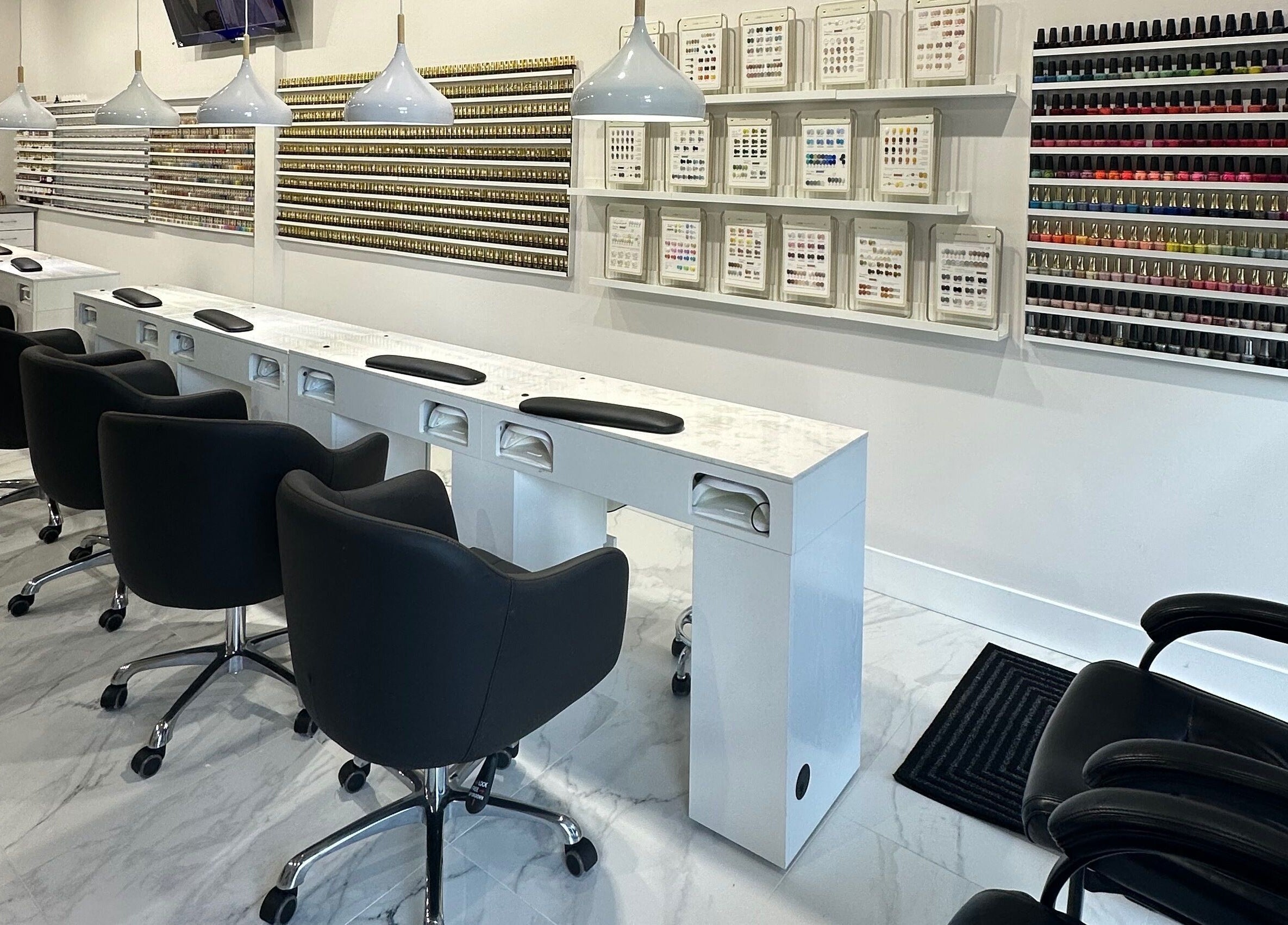 Modern nail studio at Creative Nails and Esthetics, Burnaby, BC, CA showcasing sleek seating and polish displays.