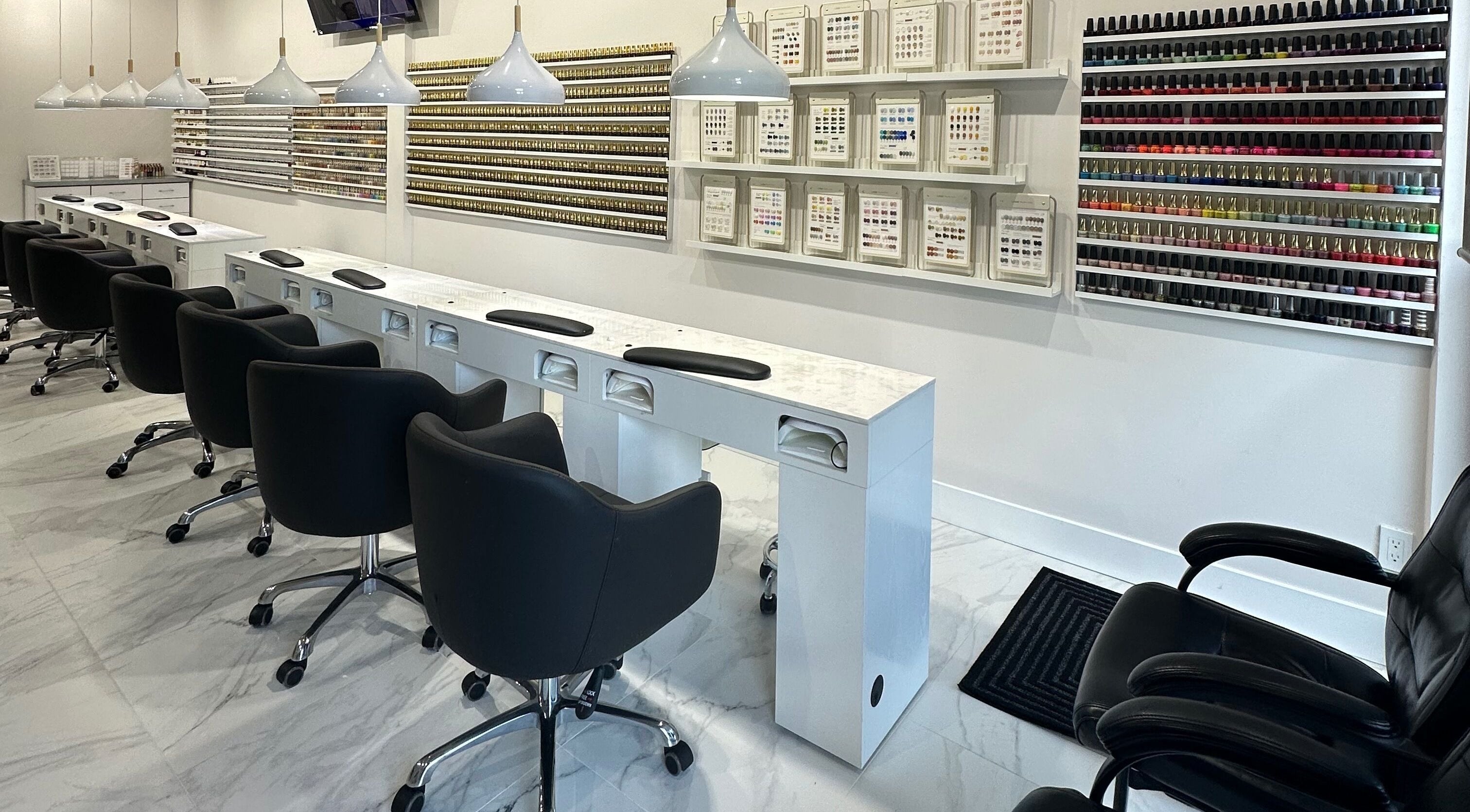 Modern nail studio at Creative Nails and Esthetics, Burnaby, BC, CA showcasing sleek seating and polish displays.