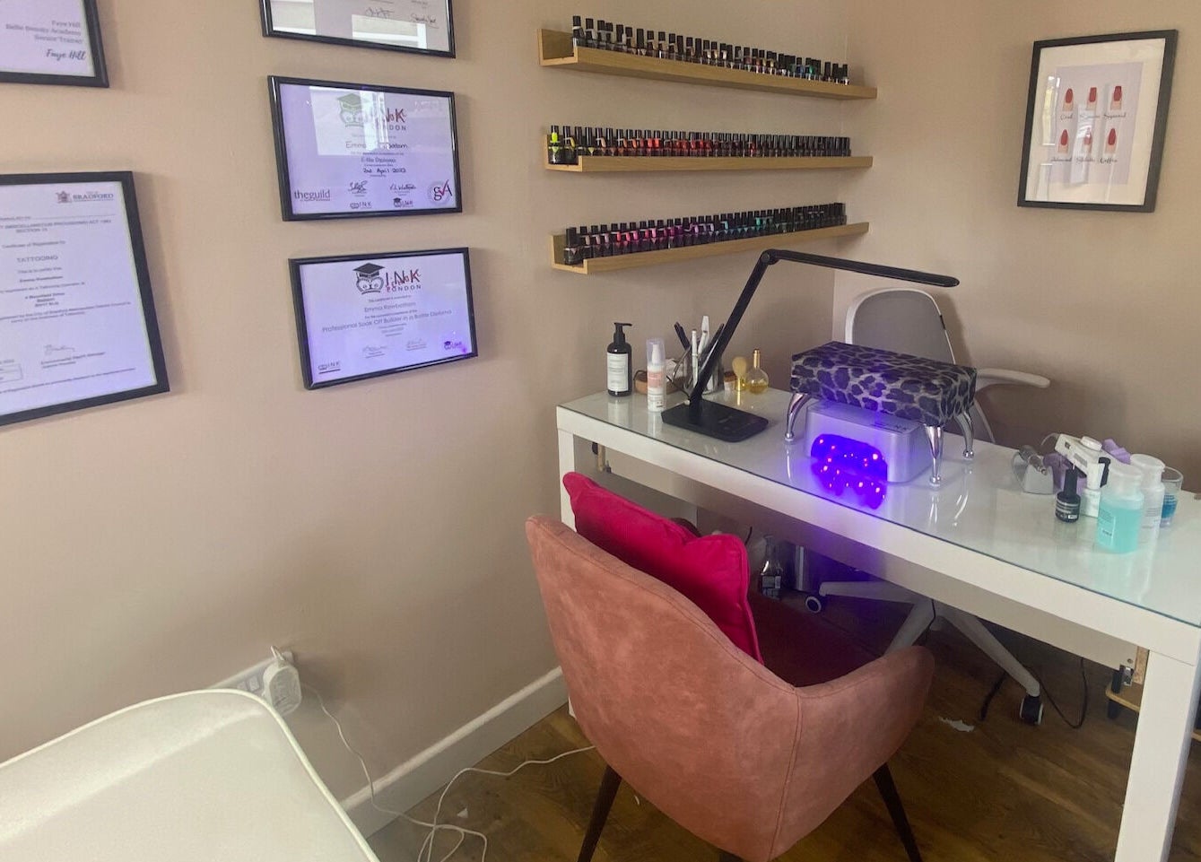 Modern nail station at Iris Nail & Brow Studio, Baildon, England, GB, with tools and certificates on the wall.