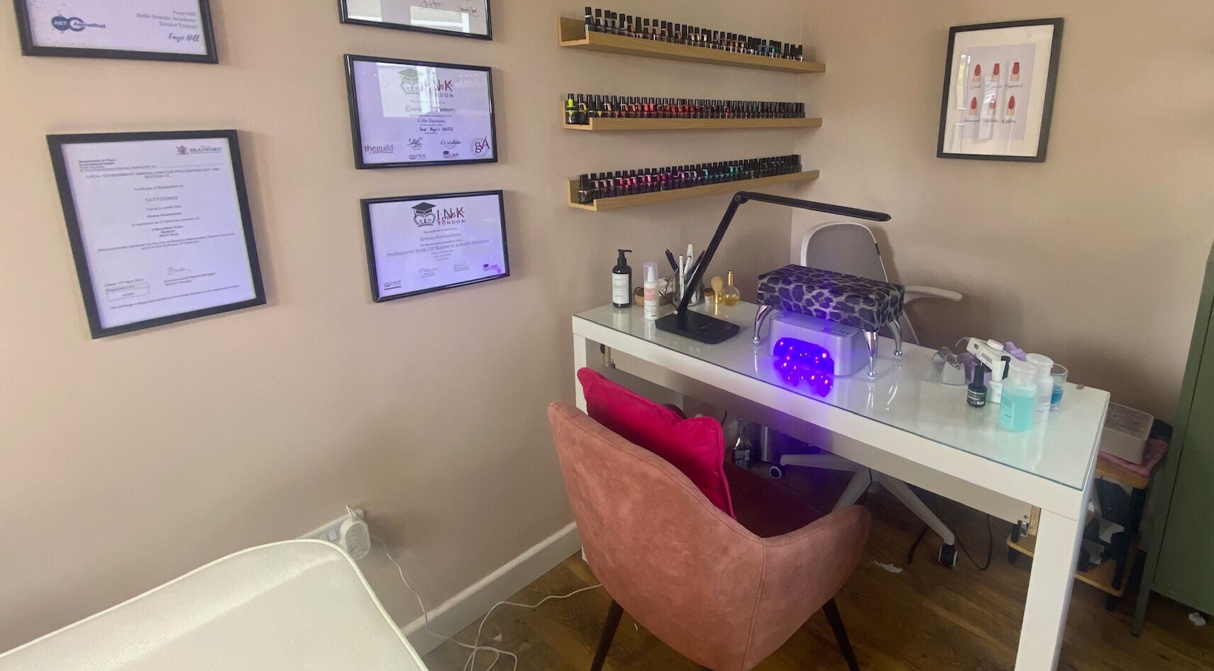 Modern nail station at Iris Nail & Brow Studio, Baildon, England, GB, with tools and certificates on the wall.