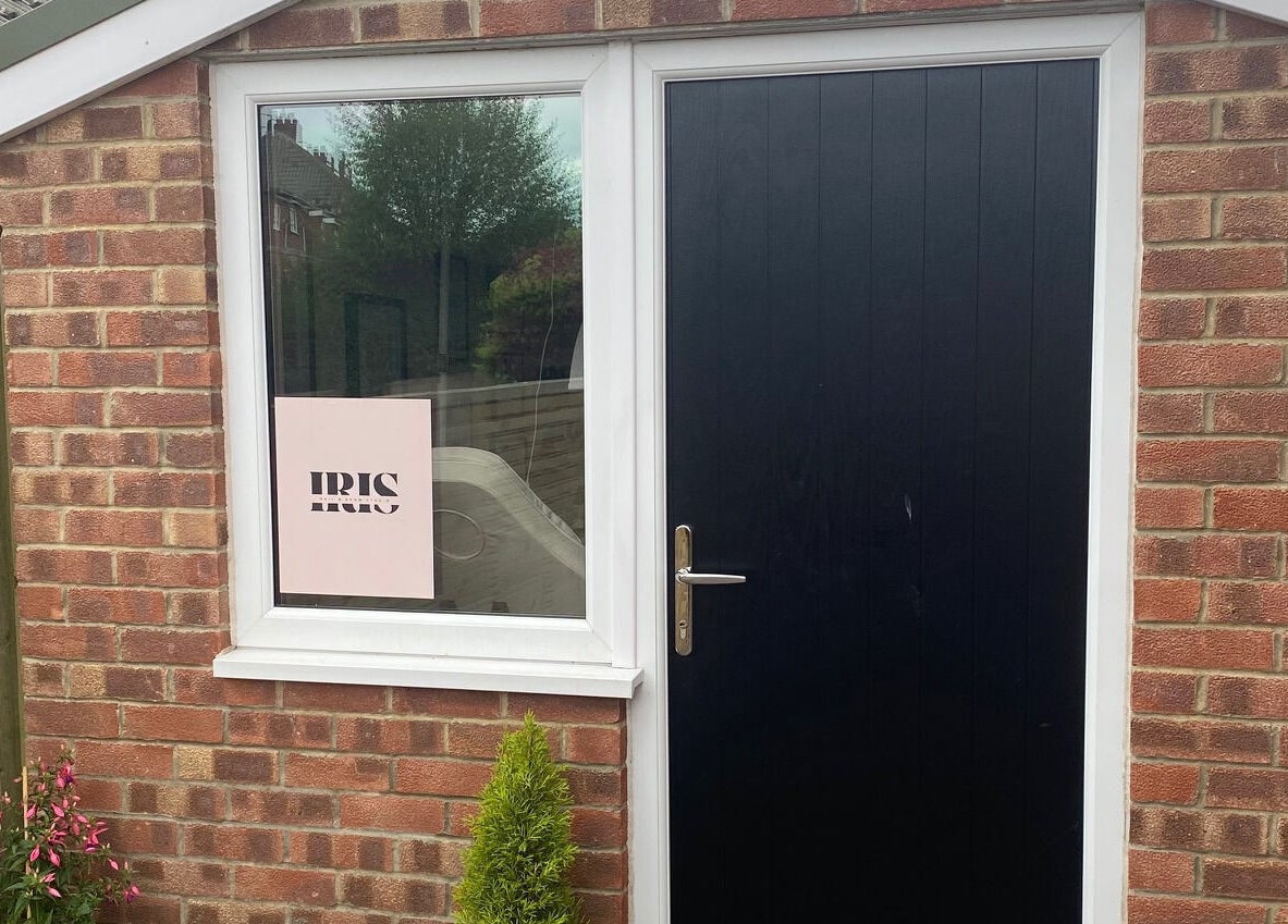 Entrance of Iris Nail & Brow Studio with black door and window sign in Baildon, England, GB.
