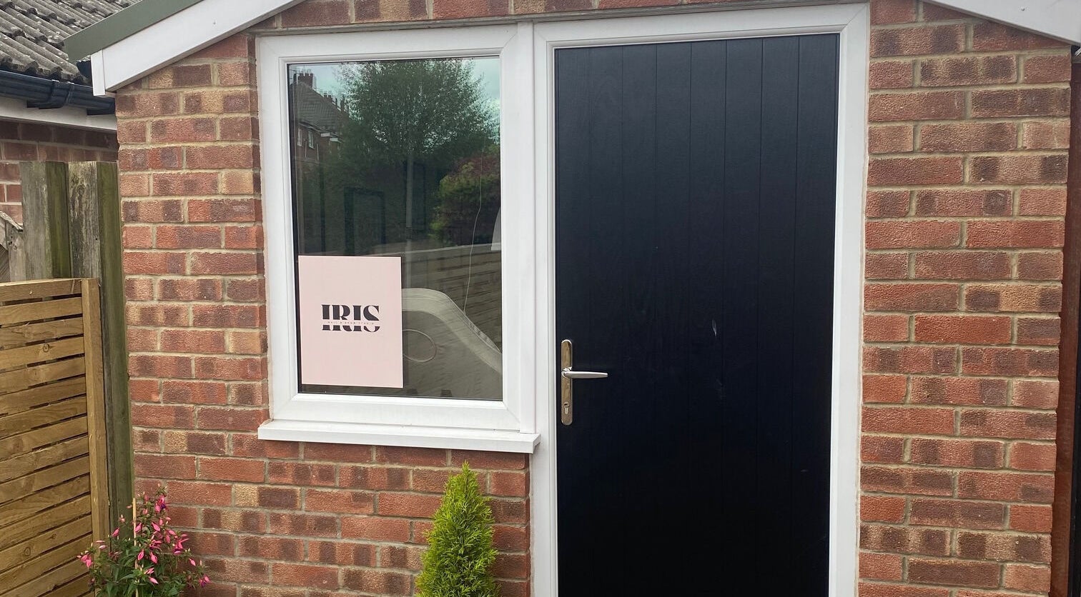 Entrance of Iris Nail & Brow Studio with black door and window sign in Baildon, England, GB.