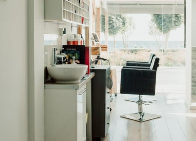 Chic interior of 7 Hair Salon, Limassol, with sea view and elegant styling chairs.