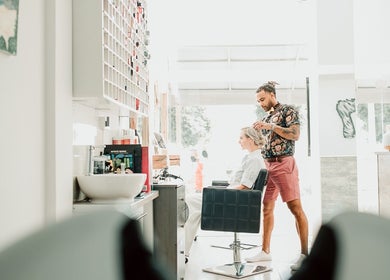 Stylist at 7 Hair Salon in Limassol, CY, attending to a client in a modern, bright space.