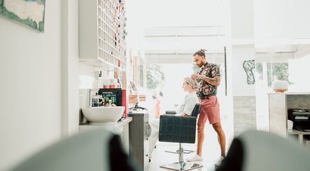 Stylist at 7 Hair Salon in Limassol, CY, attending to a client in a modern, bright space.