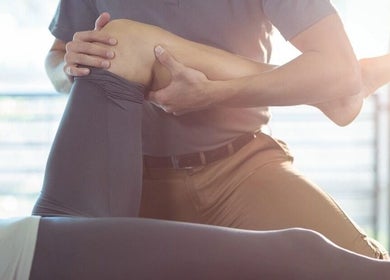 Physical therapist at Body Go Clinic in Melbourne, Victoria, AU performing rehabilitation on a client's knee.