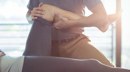 Physical therapist at Body Go Clinic in Melbourne, Victoria, AU performing rehabilitation on a client's knee.
