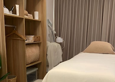 Cozy treatment room at Nadesico Beauty & Healing, Singapore, SG with soft linens and wooden decor.
