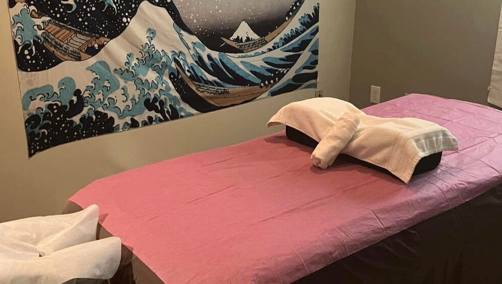 Relaxing massage room at Tropical Touch Columbus LLC in Columbus, Ohio, US, featuring calming artwork and a cozy bed.