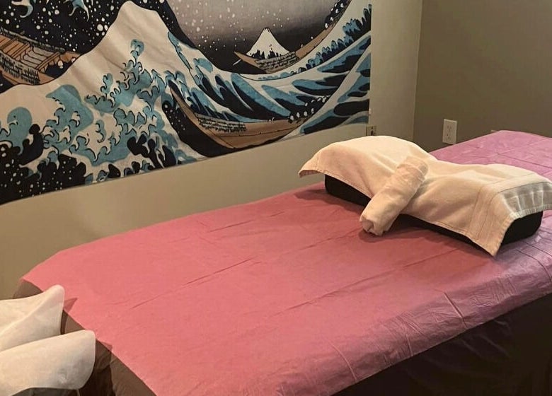 Relaxing massage room at Tropical Touch Columbus LLC in Columbus, Ohio, US, featuring calming artwork and a cozy bed.