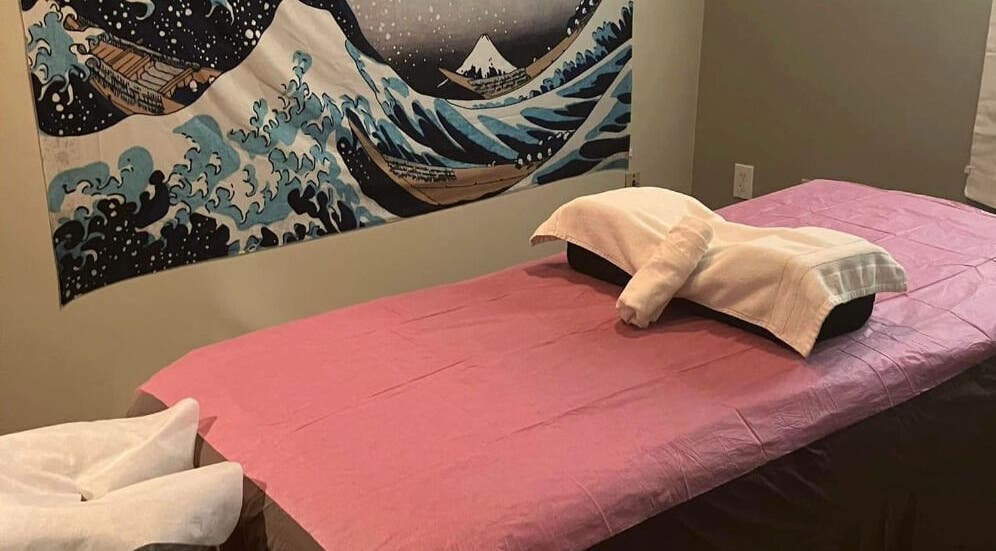 Relaxing massage room at Tropical Touch Columbus LLC in Columbus, Ohio, US, featuring calming artwork and a cozy bed.